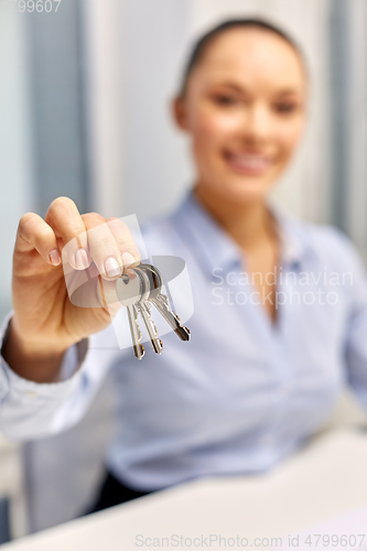 Image of businesswoman or realtor holding keys at office
