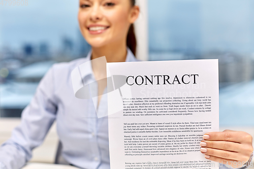 Image of happy businesswoman holding contract at office