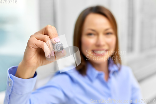 Image of businesswoman writing something in air with marker