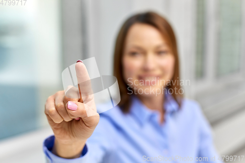 Image of businesswoman touching something with finger