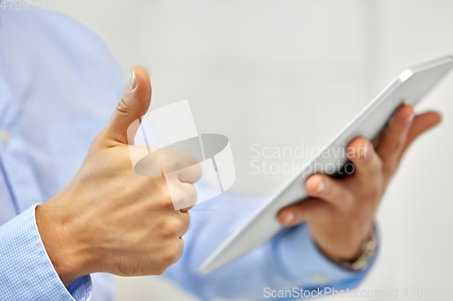 Image of close up of hands with tablet pc showing thumbs up