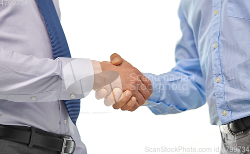 Image of close up of businessmen making handshake at office