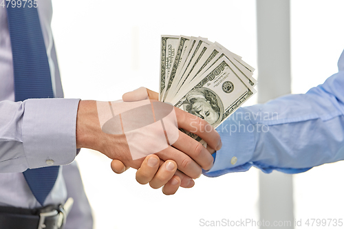 Image of close up of businessmen's hands holding money