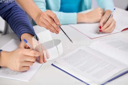 Image of hands of students with books and notebooks