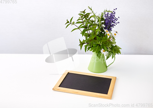 Image of bunch of herbs and flowers with chalkboard