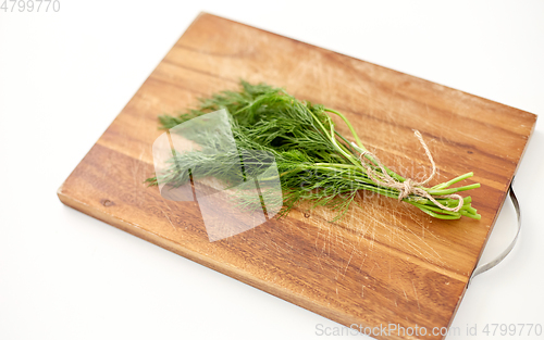 Image of bunch of dill on wooden cutting board