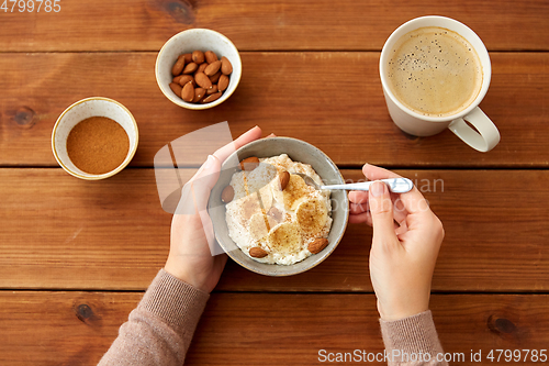 Image of hands with oatmeal breakfast and cup of coffee