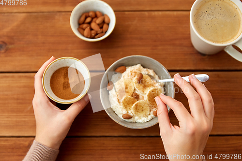 Image of hands with oatmeal breakfast and cup of coffee