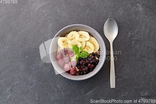 Image of oatmeal breakfast with berries, banana and spoon