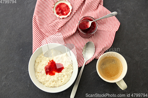 Image of porridge breakfast with jam, spoon and coffee
