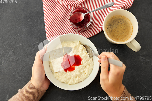 Image of hands with porridge breakfast and cup of coffee