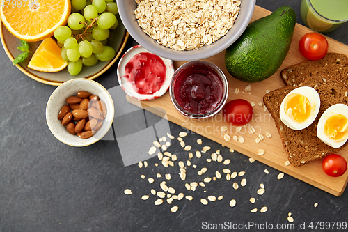 Image of oatmeal, fruits, toast bread, egg, jam and milk