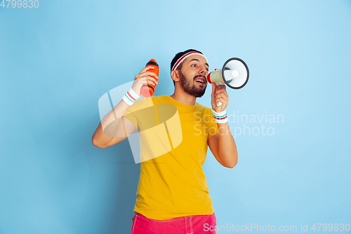 Image of Young caucasian man in bright clothes training on blue background