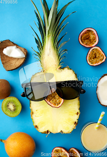 Image of pineapple in sunglasses with other exotic fruits