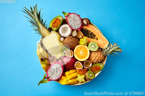 Image of plate of exotic fruits on blue background