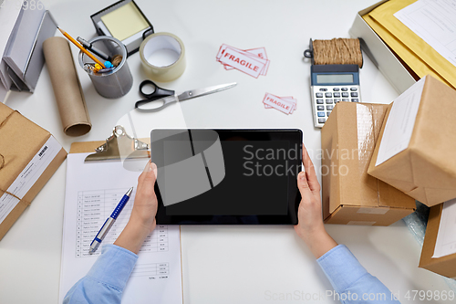 Image of hands with tablet pc and clipboard at post office