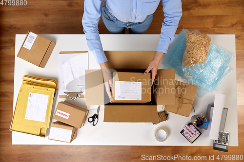 Image of woman packing parcel boxes at post office