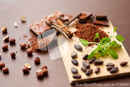 Image of chocolate with nuts, cocoa beans and cinnamon