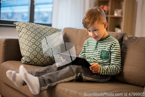 Image of happy little boy with tablet computer at home