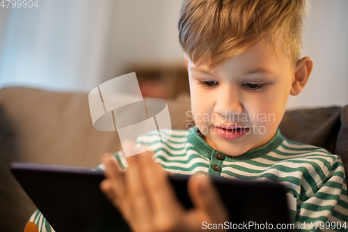 Image of happy little boy with tablet computer at home