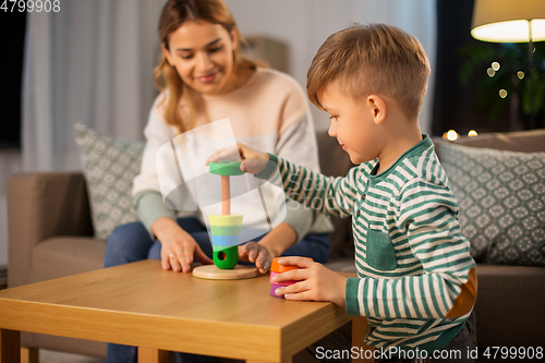Image of mother and son playing with toy pyramid at home