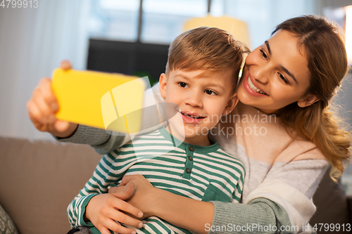 Image of mother and son taking selfie by smartphone at home