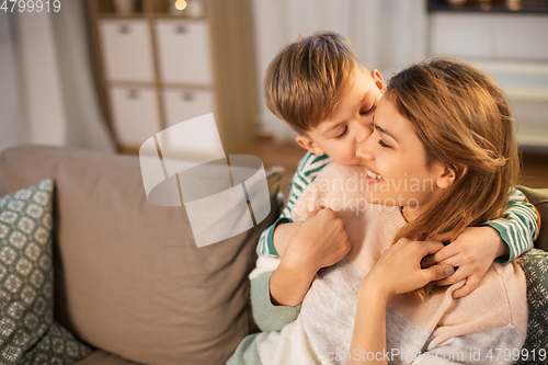 Image of happy smiling mother and son hugging at home