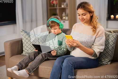 Image of mother and son using gadgets at home