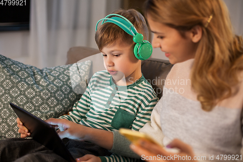 Image of mother and son using gadgets at home