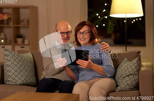 Image of happy senior couple with tablet pc at home