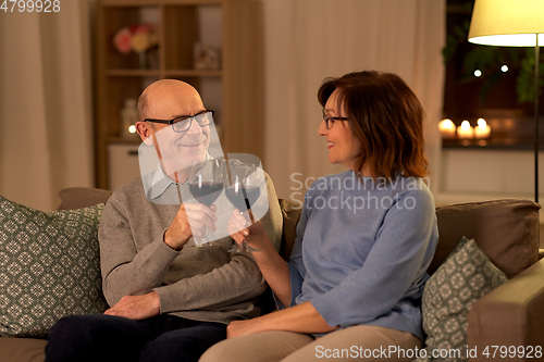 Image of happy senior couple with glasses of red wine