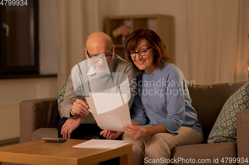 Image of senior couple with papers and calculator at home