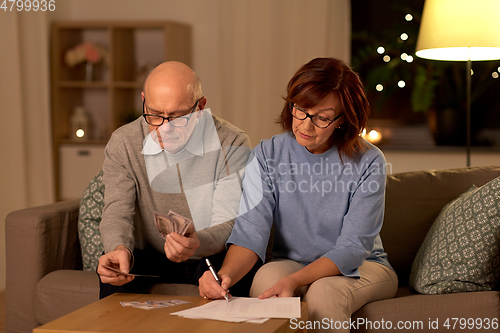 Image of senior couple with bills counting money at home