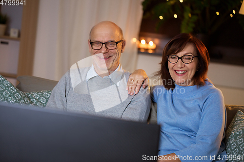 Image of happy senior couple watching tv at home