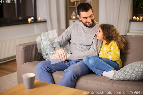 Image of happy father and little daughter at home at night