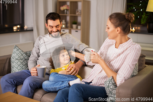 Image of portrait of happy family sitting on sofa at home