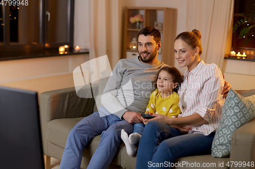 Image of happy family watching tv at home at night