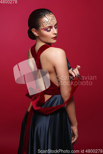 Image of beautiful woman in silk dress with red bow