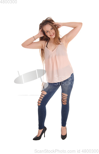 Image of Young woman standing with her hands in her hair