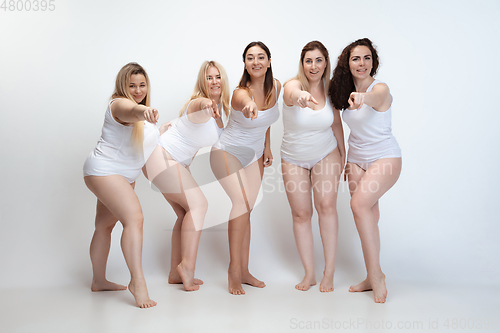 Image of Portrait of beautiful plus size young women posing on white background