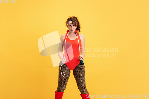 Image of Young caucasian plus size female model\'s training on yellow background
