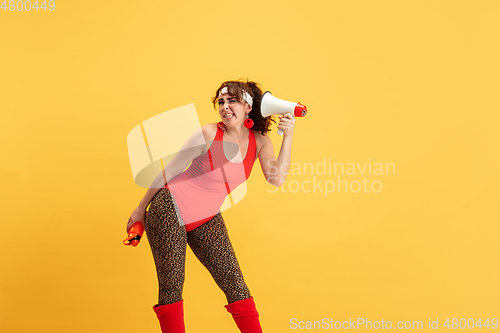 Image of Young caucasian plus size female model\'s training on yellow background