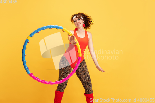 Image of Young caucasian plus size female model\'s training on yellow background