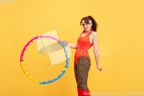 Image of Young caucasian plus size female model\'s training on yellow background