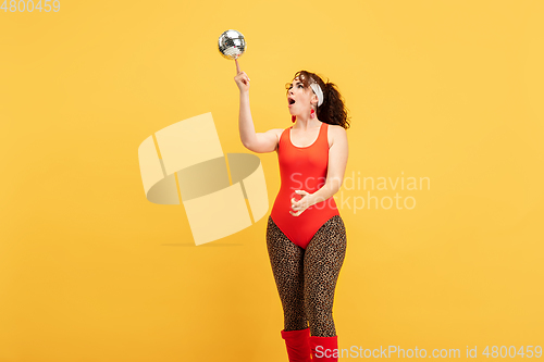 Image of Young caucasian plus size female model\'s training on yellow background