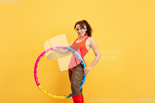 Image of Young caucasian plus size female model\'s training on yellow background