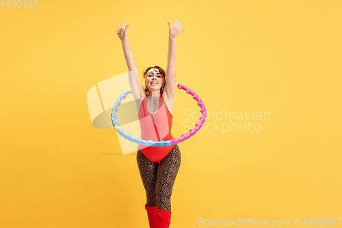Image of Young caucasian plus size female model\'s training on yellow background