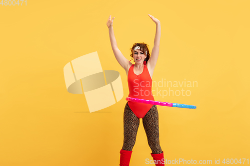 Image of Young caucasian plus size female model\'s training on yellow background