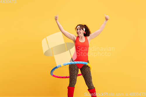 Image of Young caucasian plus size female model\'s training on yellow background