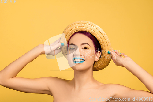 Image of Portrait of beautiful young woman with bright make-up isolated on yellow studio background